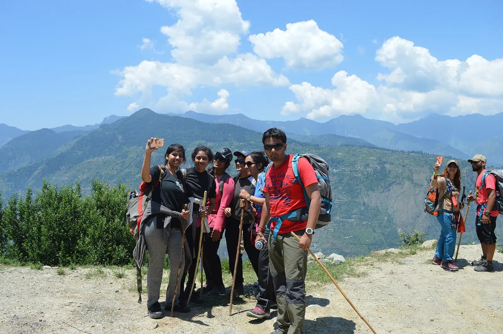 A group trekking together on a mountain trail in India
