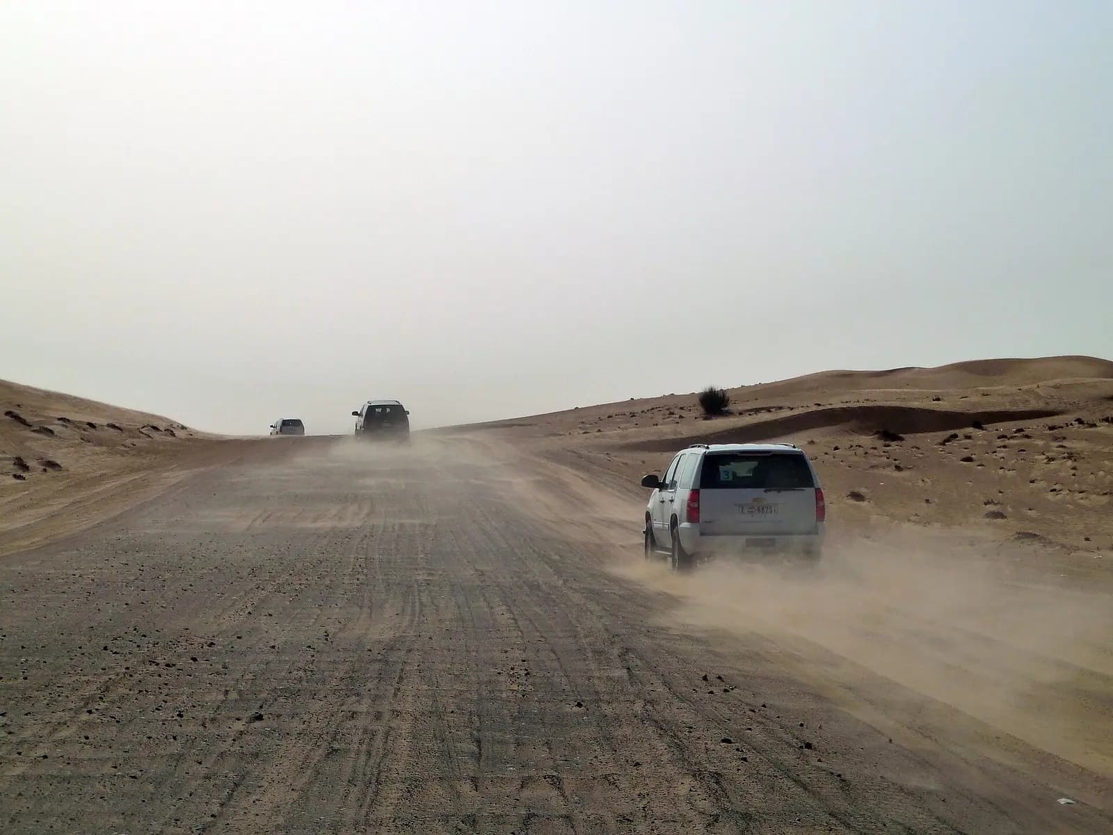 Vehicles on the red dunes of the desert outside Dubai