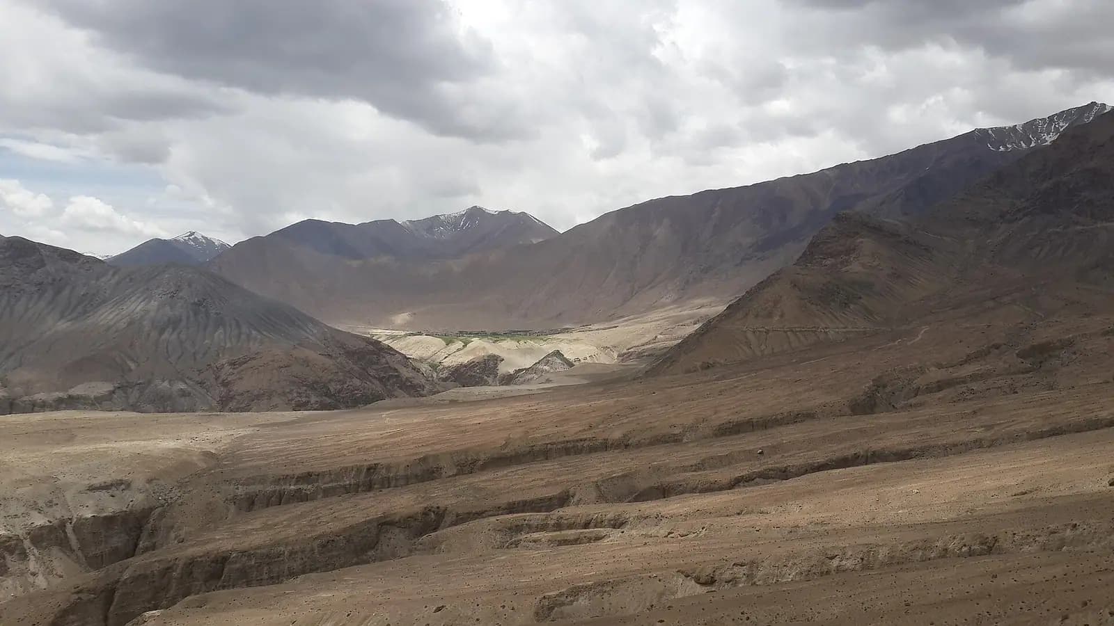 Bare ochre mountains and open sky in the high desert of Ladakh