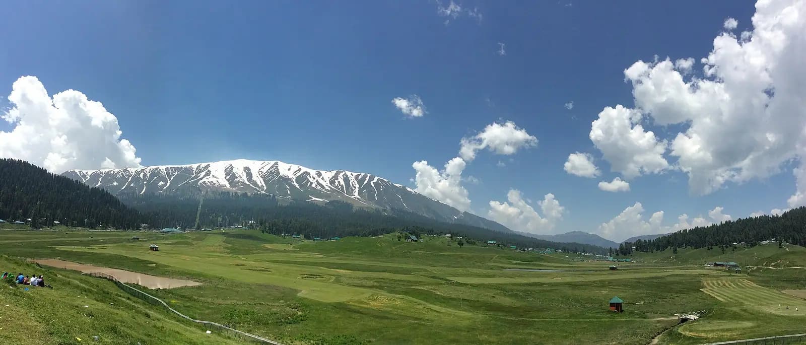 The open snow-covered meadow of Gulmarg ringed by fir forest in Kashmir