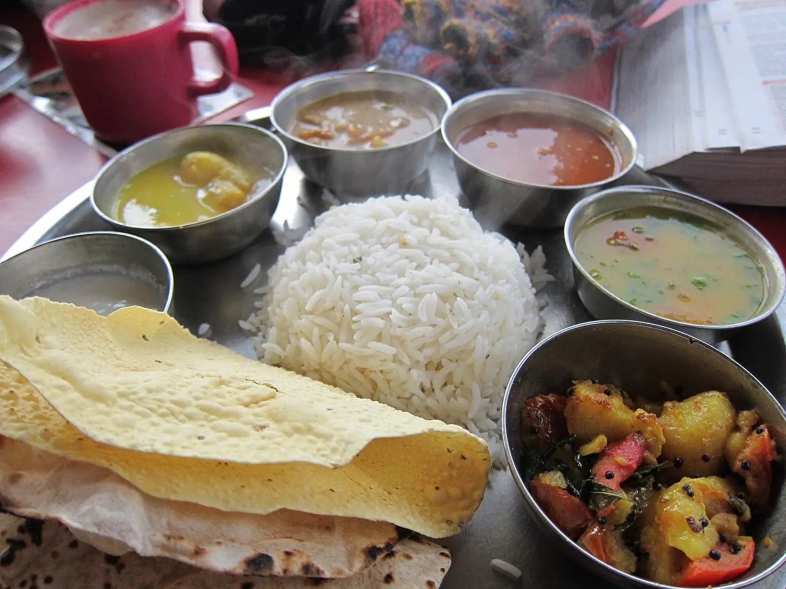 A traditional Indian thali, served the way a Himachali dham is eaten — several dishes on one plate