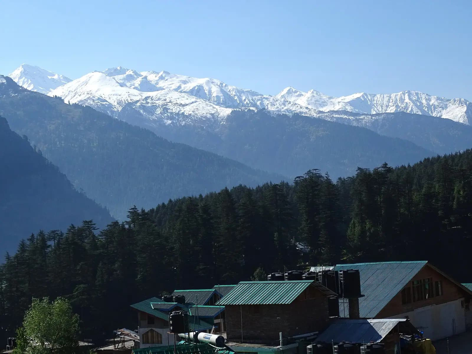 Slate-roofed houses and orchards of Old Manali on the hillside above the Kullu valley