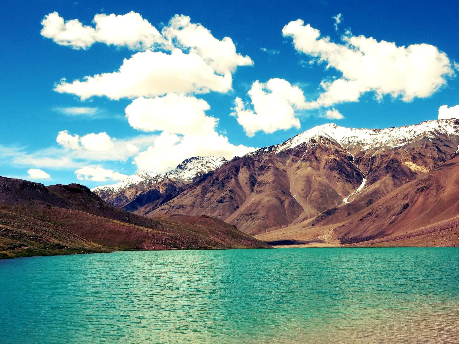 Chandratal lake held in a bowl of high-altitude mountains in Spiti, Himachal Pradesh